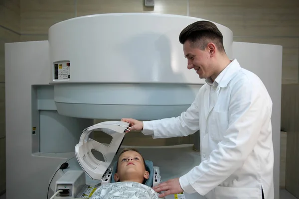 Paciente siendo escaneado y diagnosticado mediante tomografía computarizada. Los médicos examinan al niño en un tomógrafo . — Foto de Stock