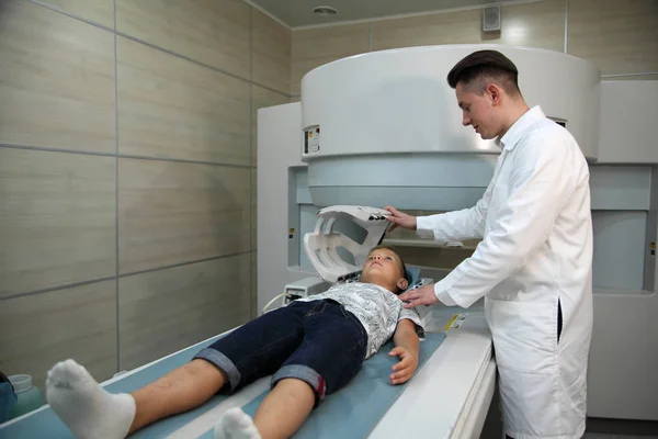 Paciente siendo escaneado y diagnosticado mediante tomografía computarizada. Los médicos examinan al niño en un tomógrafo . — Foto de Stock