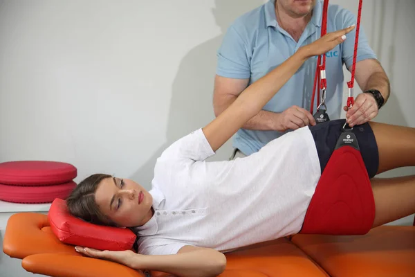 Fisioterapia: Ejercicio bajo supervisión del fisioterapeuta. Tratamiento del dolor en la columna vertebral con equipo de cuerda roja.Tratamiento del dolor agudo en la columna vertebral . —  Fotos de Stock