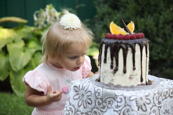 Kız doğum günü. İki yıl küçük bir beyaz saçlı kız bir doğum günü pastası çalışıyor. Küçük kız ikinci doğum günü stok görüntü kutluyor.