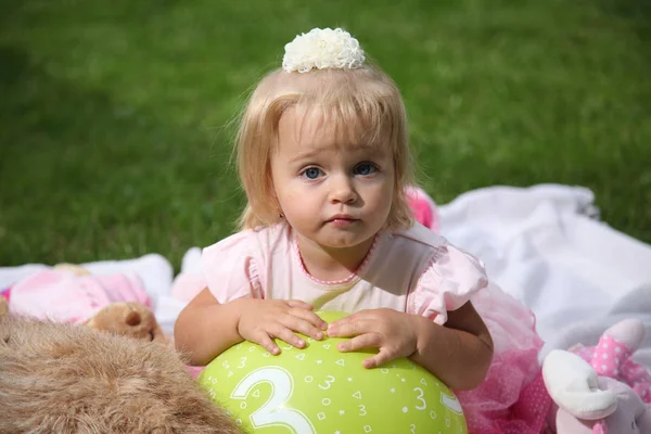 Чарівна маленька дівчинка лежить на покривалі на траві. Маленька дівчинка в саду. Дівчина лежить на обкладинці стокове зображення — стокове фото