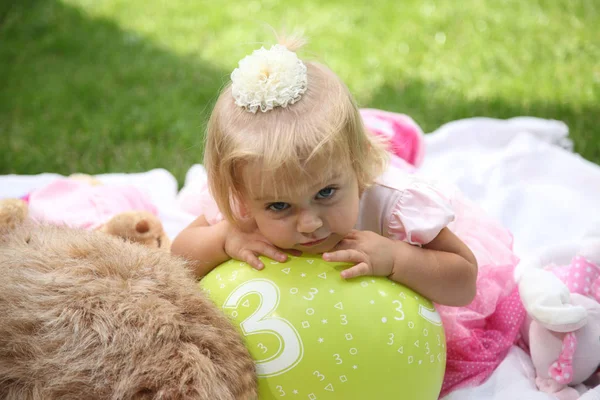 Adorable little girl lying on coverlet on grass. Little girl in the garden. Girl lying on coverlet  stock image — Stock Photo, Image