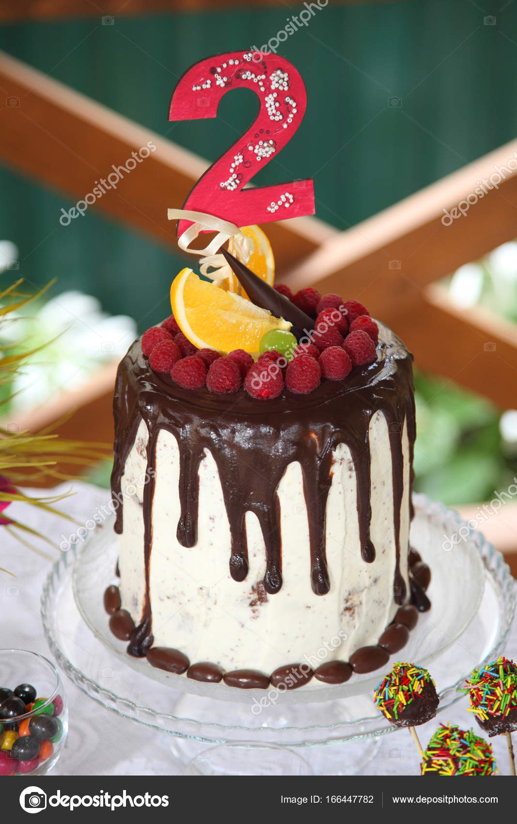 A Festive Table Decorated With Birthday Cake With Flowers And