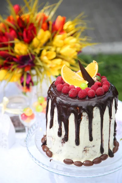 Uma mesa festiva decorada com bolo de aniversário com flores e doces. Uma mesa com um bolo para o aniversário da criança. Festa de aniversário para crianças . — Fotografia de Stock