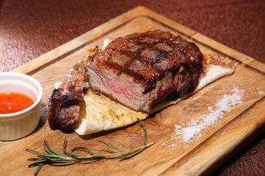 Orta kızarmış biftek sosu ve baharatlar ile ahşap bir gemide parçalar halinde kesilmiş.