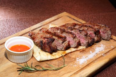 Orta kızarmış biftek sosu ve baharatlar ile ahşap bir gemide parçalar halinde kesilmiş.