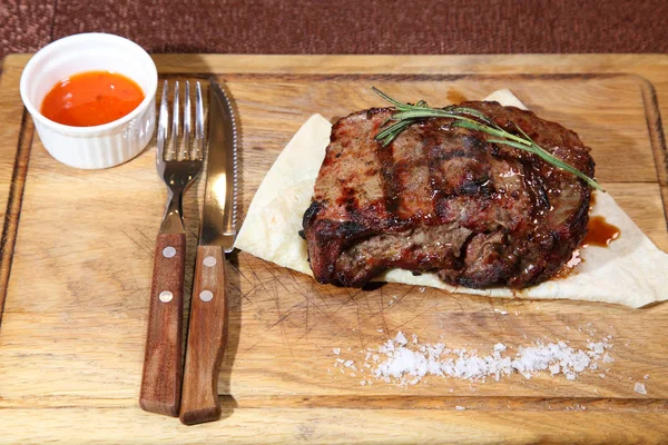 Steak Medium Braten auf einem Holzbrett mit Sauce und Salz. — Stockfoto
