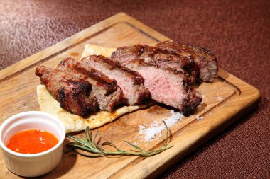 Orta kızarmış biftek sosu ve baharatlar ile ahşap bir gemide parçalar halinde kesilmiş.