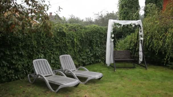 Balançoire décorée pour une cérémonie de mariage dans la cour de la maison. Le mariage oscille sous la pluie. Balançoire décorée pour une cérémonie de mariage .