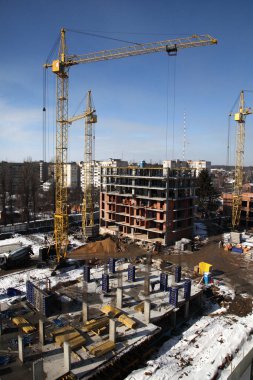 Gökyüzü arka planında vinçleri olan inşaat alanı. 
