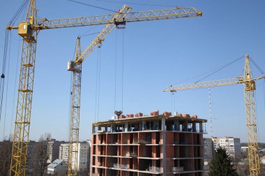 Evin inşaat çalışma crane. Şantiye ile gökyüzü arka plan üzerinde Vinçler. 