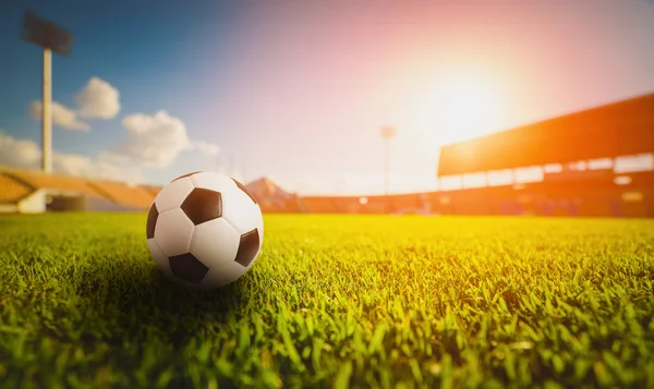 Minge de fotbal pe iarba de iarbă din stadionul de fotbal, apus de soare — Fotografie, imagine de stoc