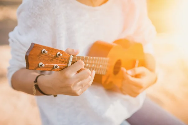 Genç kadın ukulele üzerinde oynama 