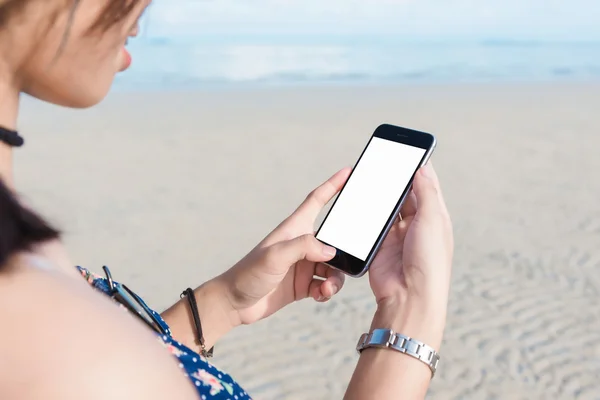 Rękę za pomocą inteligentnego telefonu na plaży. — Zdjęcie stockowe