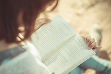 Bir kitap okuma genç bir kadın. Kadın elinde kitap