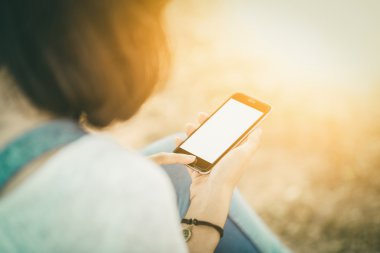 kız ile smartphone Park'ta açık havada. Eller closeup