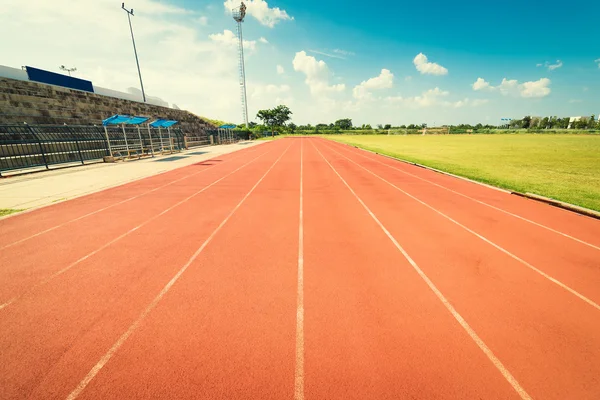 Pista roja en el estadio. Pista de carreras en el cielo azul . —  Fotos de Stock