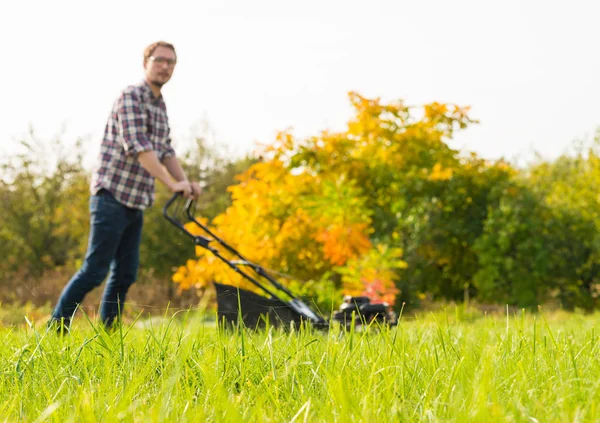 Jeune homme tondre l'herbe — Photo