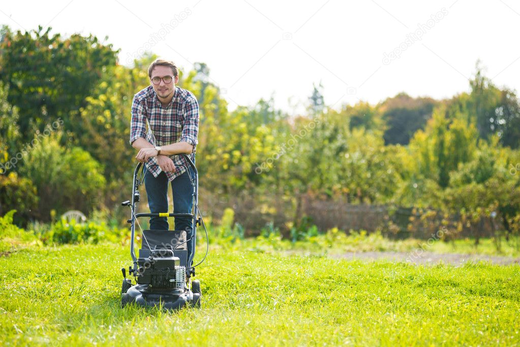 Young man mowing the grass 