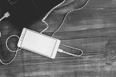 Dizüstü bilgisayar ve ahşap de boş smartphone şarj çalışma alanı