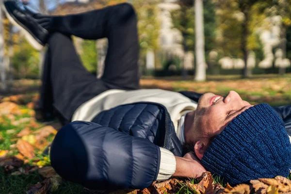 Happy young man relaxing in the park among fall n leaves . — Stok Foto
