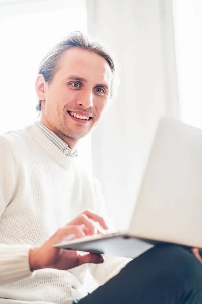 Un joven mirando su computadora portátil. Luz brillante en el —  Fotos de Stock