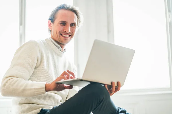 Jeune homme regardant son ordinateur portable. Lumière vive dans la Images De Stock Libres De Droits