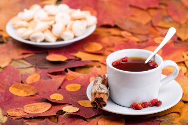 Sonbahar bir arka plan üzerinde kurabiyeyle çay yaprakları   