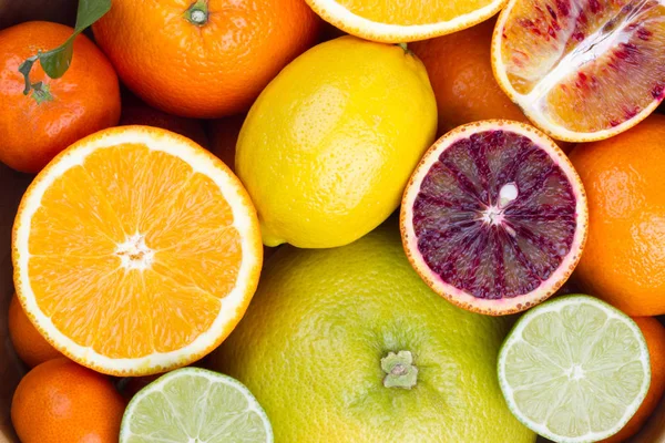 Citrus: whole and half to a wooden bowl. — Stock Photo, Image