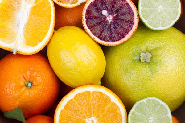 Citrus: whole and half to a wooden bowl. — Stock Photo, Image