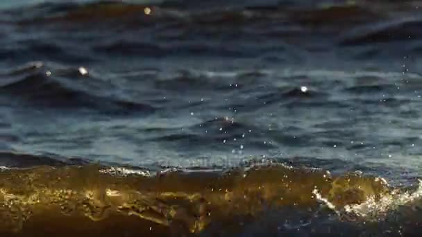 Malé vlny bublající vody pohybovat podél povrchu zálivu moře. Voda svítí a má nažloutlý odstín kvůli nastavení