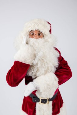Noel Baba gözlük ve beyaz arka plan üzerinde duran ve kameraya bakarak kırmızı kostüm. 