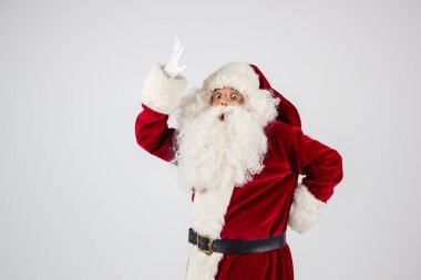 Noel Baba gözlük ve kırmızı kostüm beyaz arka plan ve kameraya bakarak elleri olan bir nokta yapmak. 