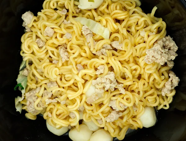 Yellow instant noodle in black bowl, Closeup top view — Stock Photo, Image