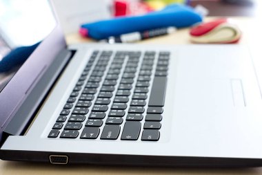 Office çalışma alanı ile ahşap masa, select odak üstünde klavye laptop ve office kaynağı.