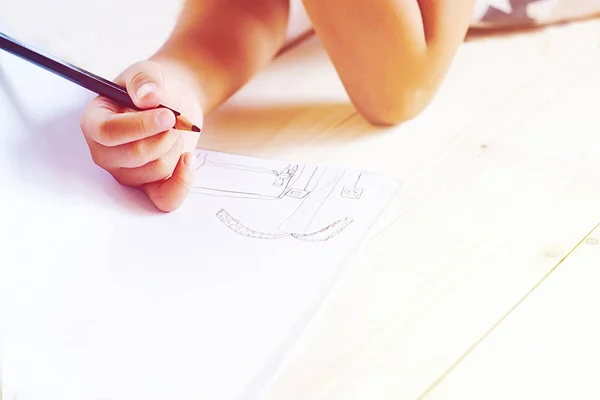 Little kid's hand iets tekenen op wit papier. — Stockfoto
