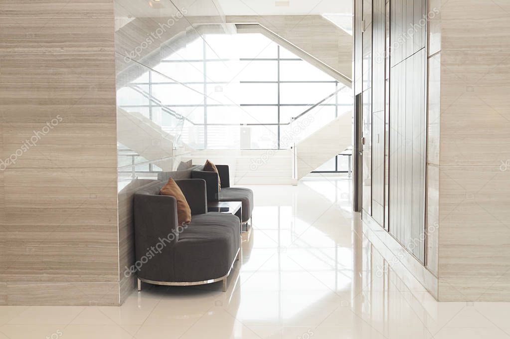 Modern sofa in lobby of hotel with glass window background