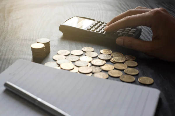 Gros plan main de l'homme à l'aide d'une calculatrice avec des pièces d'or, stylo, ordinateur portable sur table noire. Business, finance, marketing, e-commerce concept et design — Photo