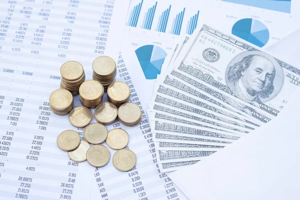 Stack of coins and dollar banknote on blue pastel chart paper. Business, finance, marketing, e-commerce concept and design.