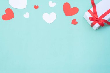 Gift box, red and white hearts on blue pastel background. Valentine's day or wedding ceremony concept and design