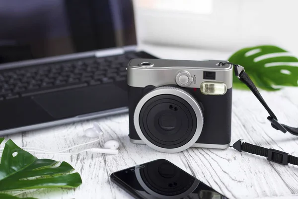 Ordenador portátil, hojas, cámara retro, teléfono móvil en blanco — Foto de Stock