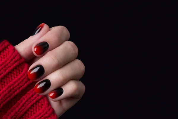 Female hand with red black ombre gradient nails in sweater — Stock Photo, Image