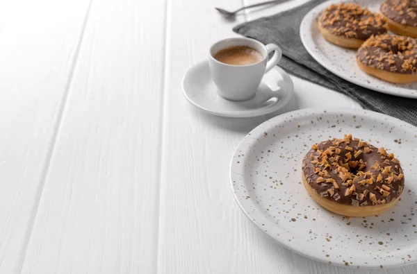 Composición con rosquillas vidriadas en un plato sobre mesa de madera blanca . — Foto de Stock