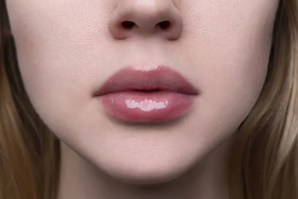 Güzel bir kadının dolgun, dolgun dudaklarını çıplak dudak parıltısıyla kapat.