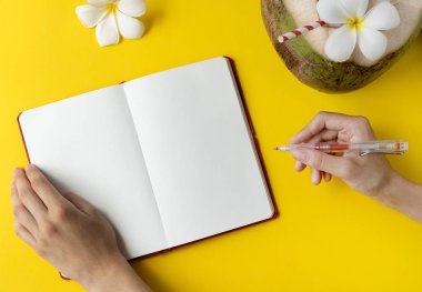 Taze hindistan cevizi içeceği, boş not defterini aç ve kadınların ellerini bağır.