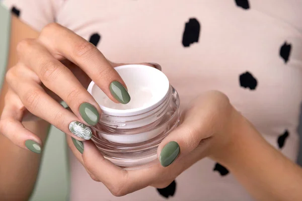 Woman with manicure holding a jar of cosmetic cream — Stock Photo, Image