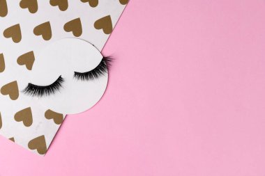 Kirpikleri olan yaratıcı bir düzen. Pastel pembe arka planda kapalı gözler. Minimum şablon kartpostal Günaydın konsepti.