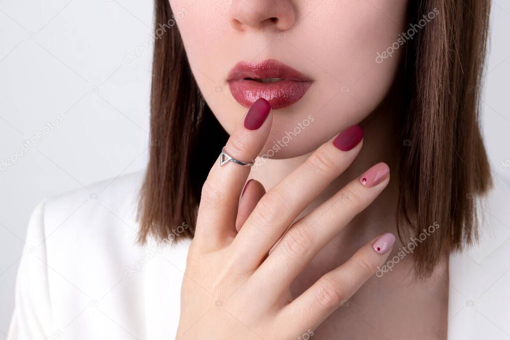 Beautiful woman with a pink manicure in minimal style with jewelry. Summer nail design. Fashion makeup and hands care concept