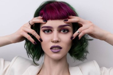 Mor yeşil renkli, profesyonel saçı olan güzel bir kadın. Parlak gözler ve dudak makyajı. Kısa saçlı ve piercingli moda kızı.. 