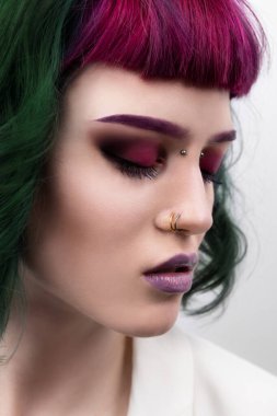 Mor yeşil renkli, profesyonel saçı olan güzel bir kadın. Parlak gözler ve dudak makyajı. Kısa saçlı ve piercingli moda kızı.. 